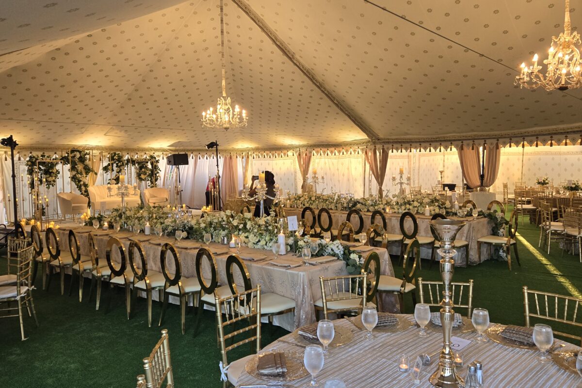 Regal Victorian-style tent with ornate drapes set up for a large seated dinner