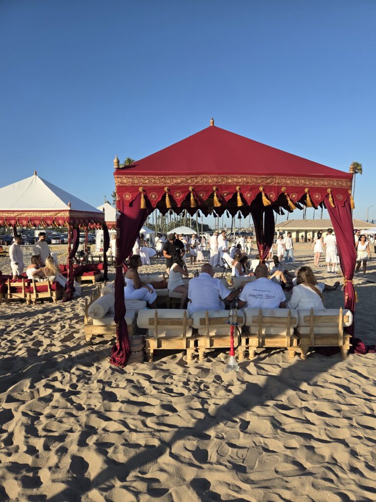 Beach tent lounge rental with royal seating and traditional red and white canopy tents