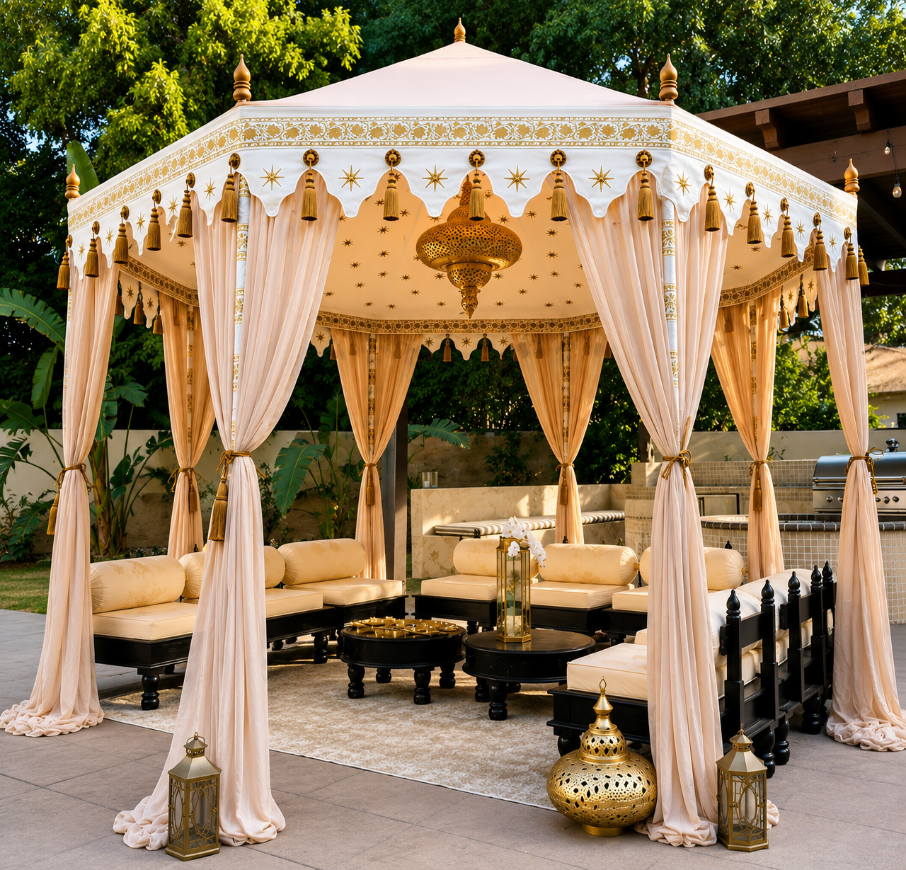 Elegant outdoor canopy lounge with cream drapes, gold tassels, and plush beige seating under a decorative gazebo.